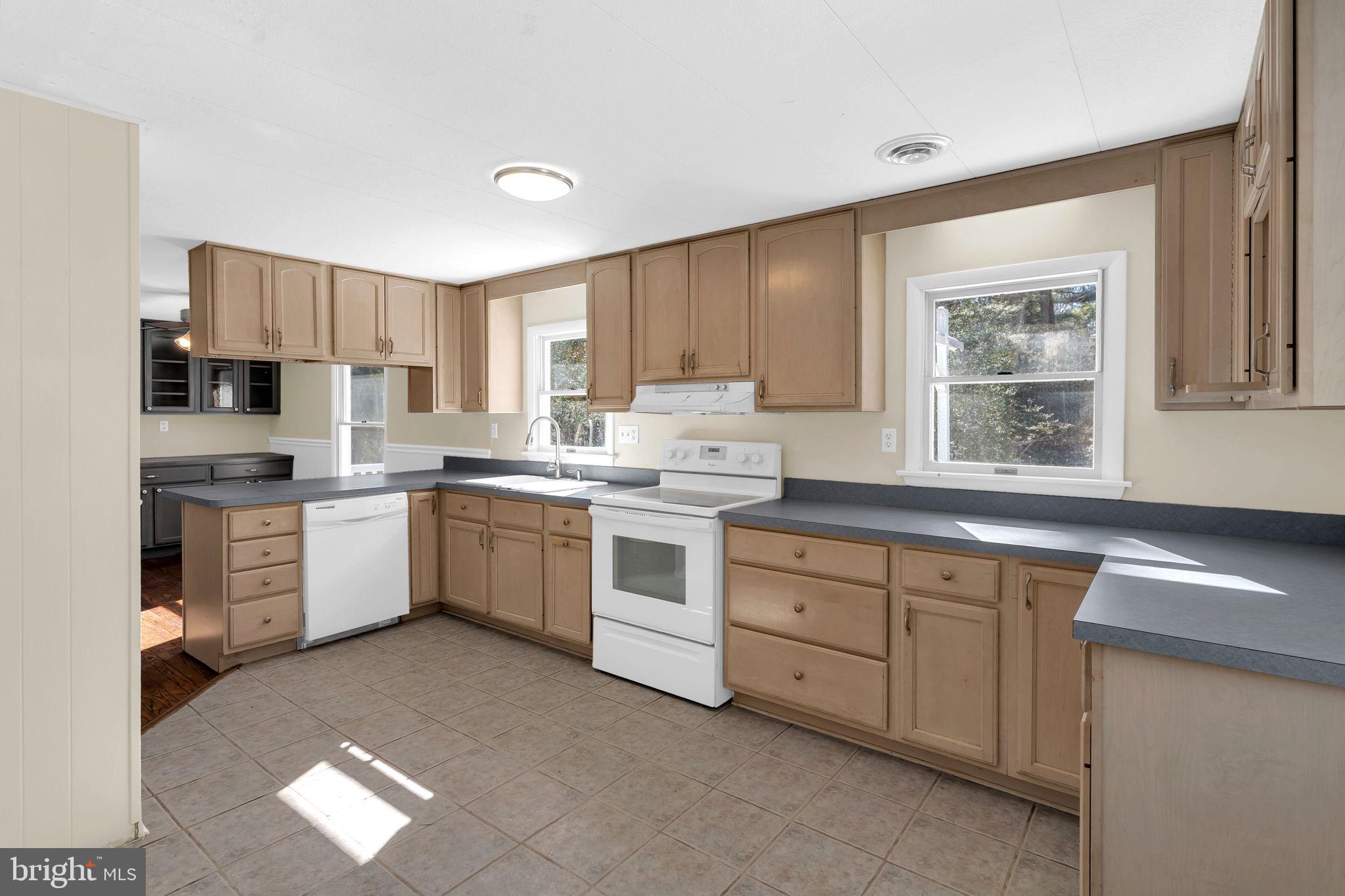 1150 Calvert Beach Road St. Leonard, MD 20685 - Photo 4 of 42 a kitchen with a white stove top oven and white cabinets