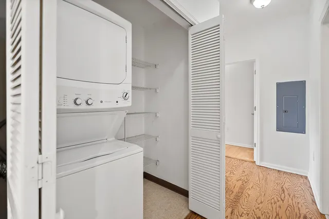 a room with a bench and white cabinets