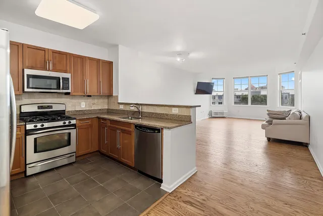 a kitchen with stainless steel appliances granite countertop a refrigerator stove and microwave