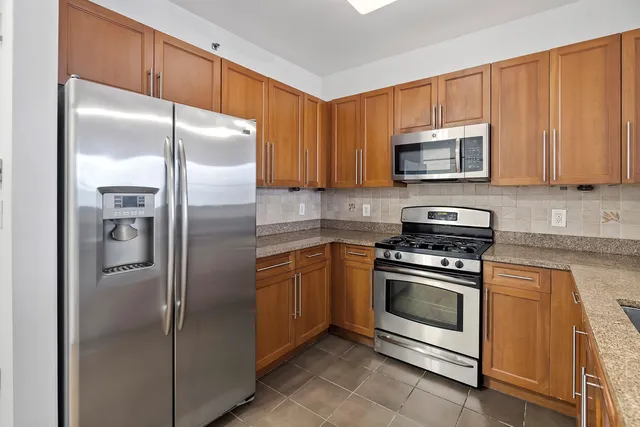 a kitchen with stainless steel appliances granite countertop a sink stove and microwave