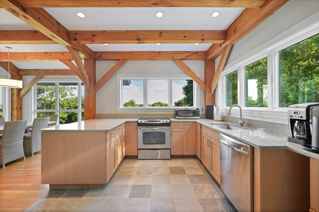 169 S Road Bourne, MA 02559 - Photo 35 of 42 a large kitchen with stainless steel appliances granite countertop a stove a sink and a refrigerator