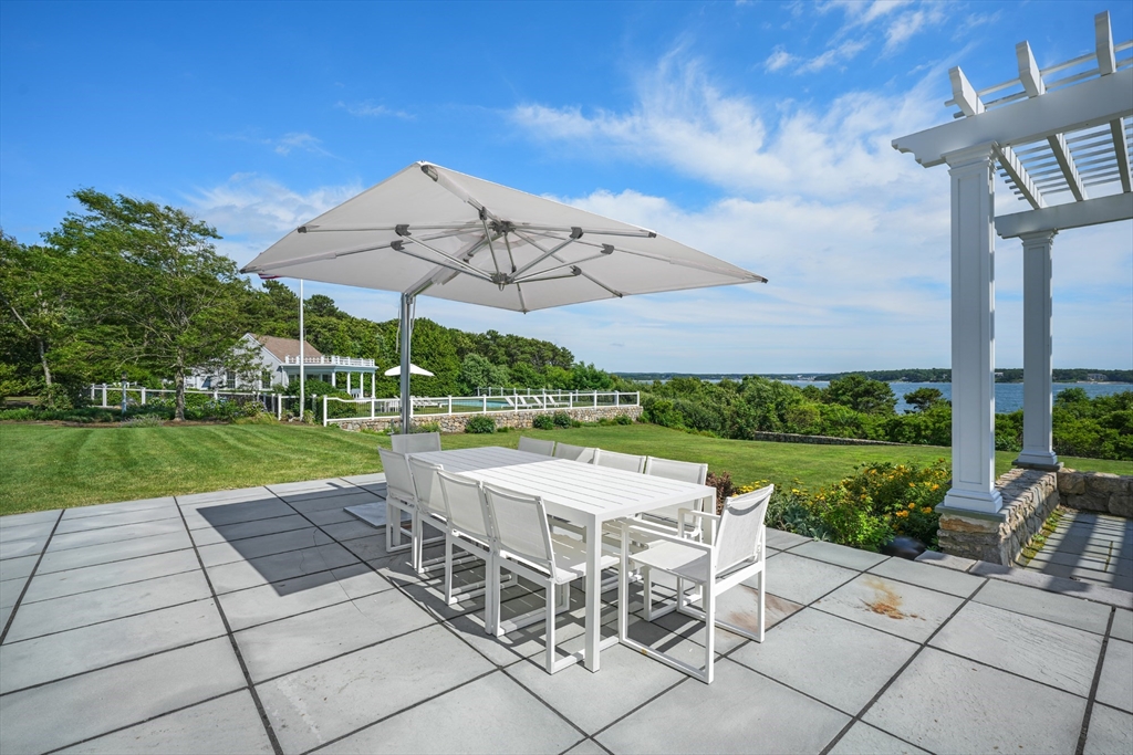 169 S Road Bourne, MA 02559 - Photo 6 of 42 a view of a with table and chairs under an umbrella