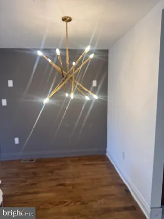 a view of an empty room with a chandelier fan