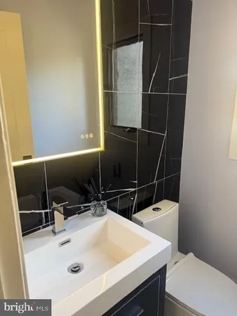 a bathroom with a sink a toilet and a mirror