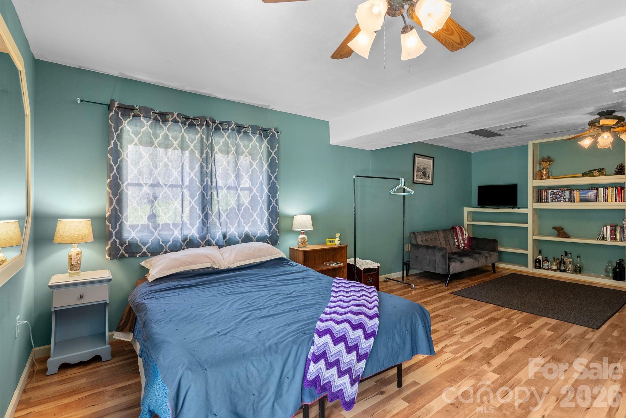 10 Gentry Branch Road Weaverville, NC 28787 - Photo 21 of 33 a bedroom with a bed and a chandelier