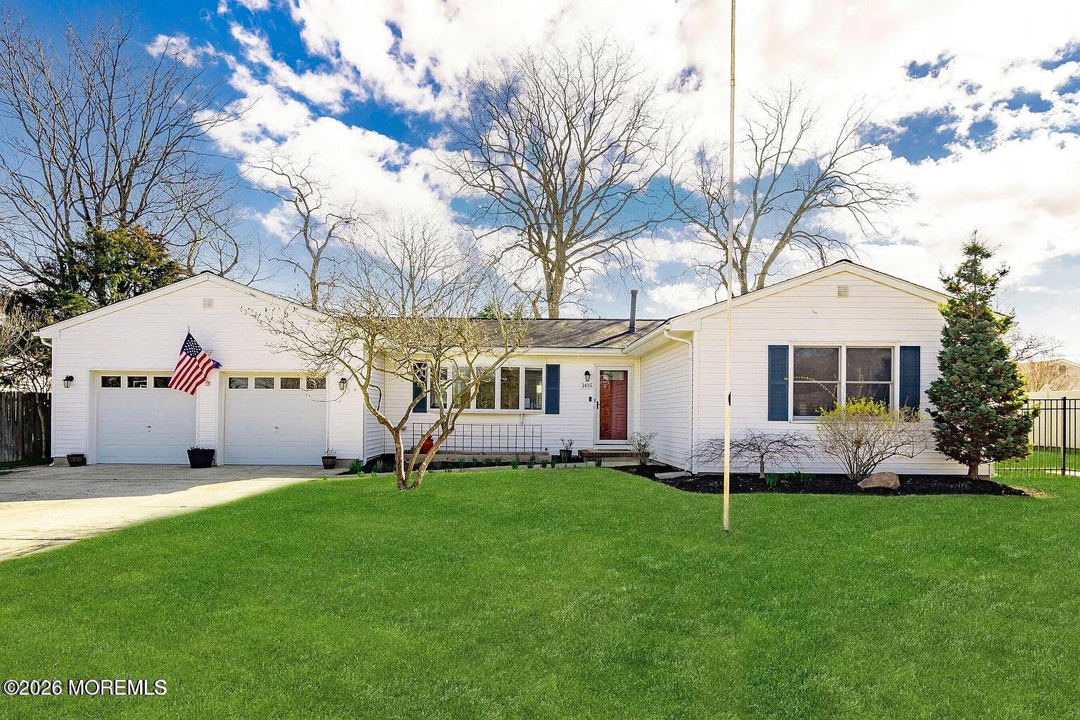a front view of house with garden and trees