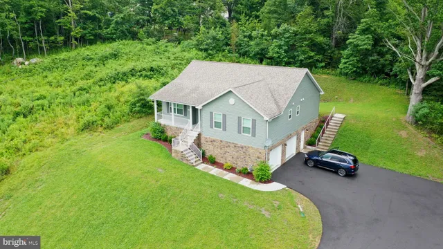 a aerial view of a house with a yard table and chairs