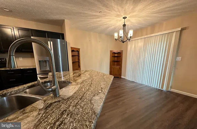 a kitchen with stainless steel appliances granite countertop a refrigerator and a sink