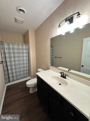 a bathroom with a sink a toilet a shower and a mirror