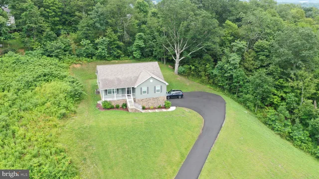 a view of a house with a big yard and large trees