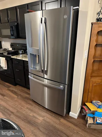a metallic refrigerator freezer sitting in a kitchen