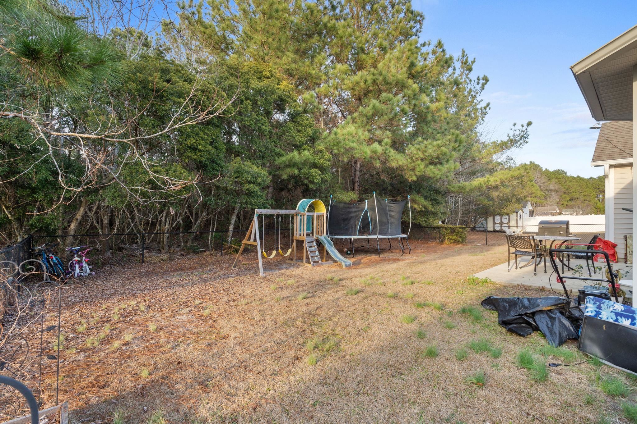 452 West Perry Road Myrtle Beach, SC 29579 - Photo 12 of 26 Fenced backyard with a playground, a trampoline, and a patio
