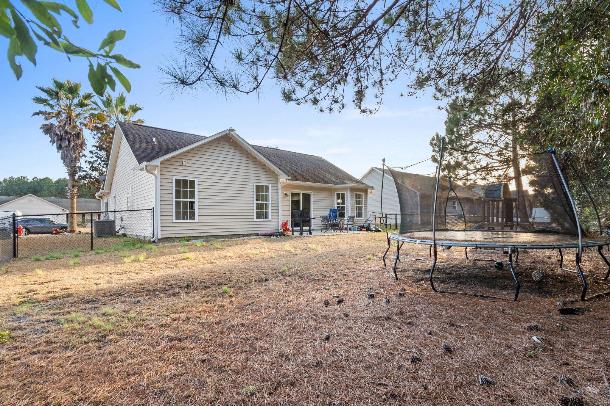 452 West Perry Road Myrtle Beach, SC 29579 - Photo 14 of 26 Back of property with a patio, a fenced backyard, and a trampoline