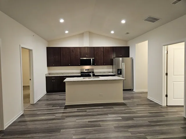 a kitchen with stainless steel appliances granite countertop a refrigerator sink and cabinets