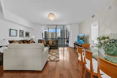 a spacious bedroom with a bed couch chandelier and a window