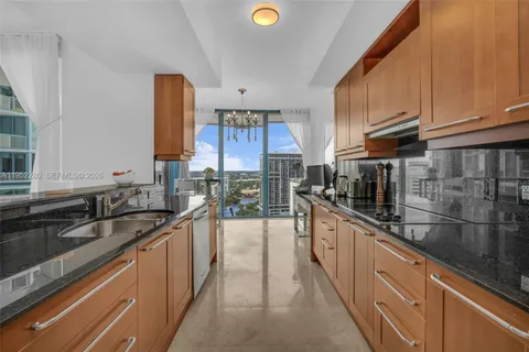 a kitchen with granite countertop a sink and refrigerator