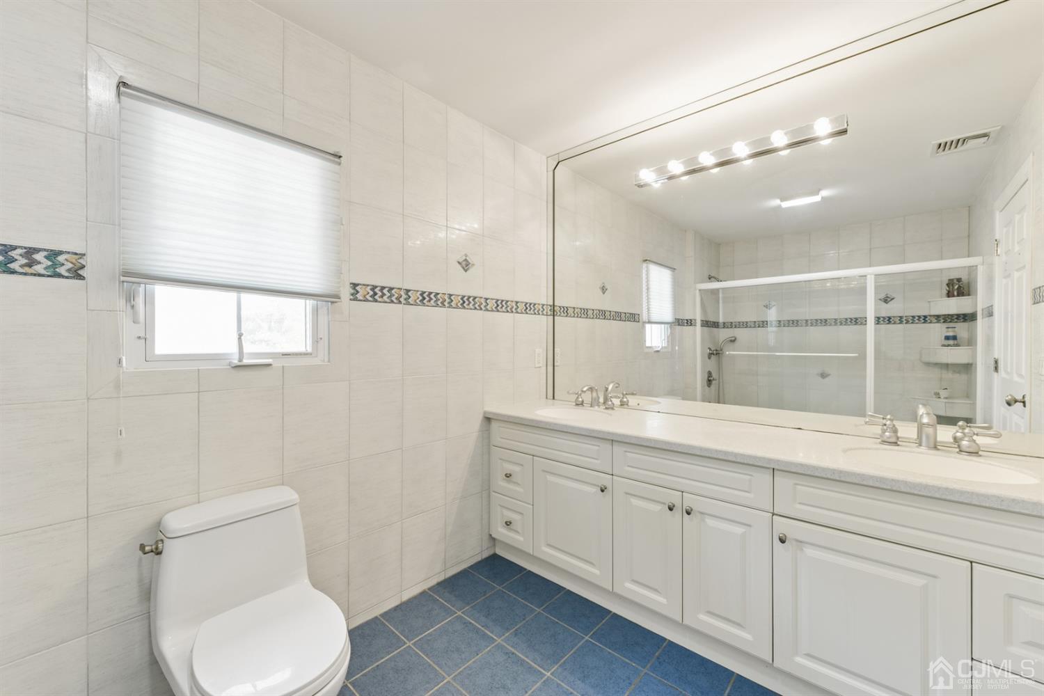 27 Agate Road East Brunswick, NJ 08816 - Photo 19 of 31 a bathroom with a toilet a sink a mirror and a shower