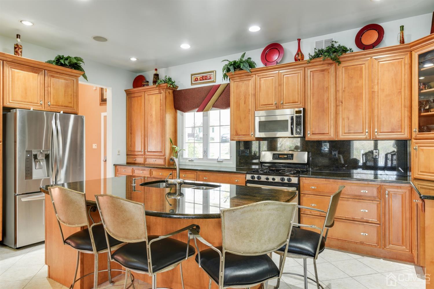 27 Agate Road East Brunswick, NJ 08816 - Photo 4 of 31 a kitchen with stainless steel appliances granite countertop a stove top oven a sink dishwasher and chairs with wooden floor