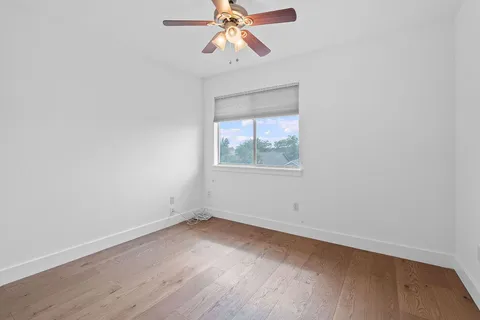 an empty room with a window and a fan