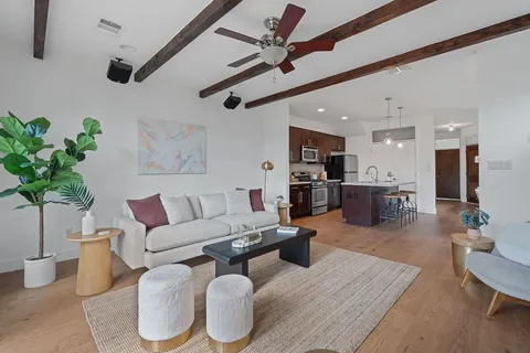 a living room with furniture kitchen view and a potted plant