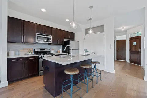 a kitchen with kitchen island a sink stove and refrigerator