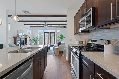 a kitchen with stainless steel appliances granite countertop a sink stove and cabinets