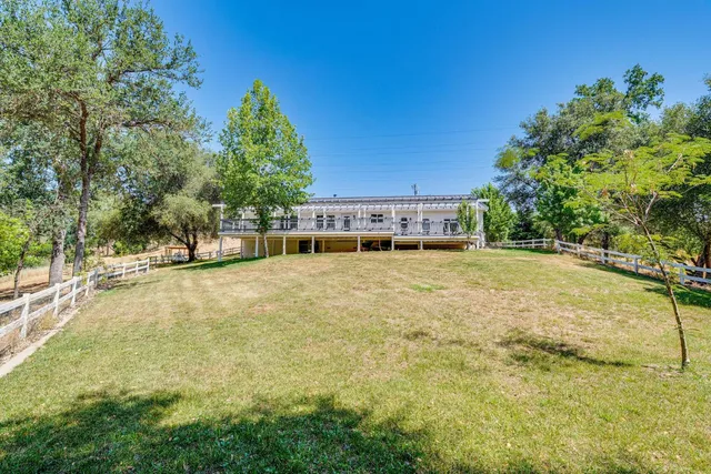 a backyard of a house with table and chairs
