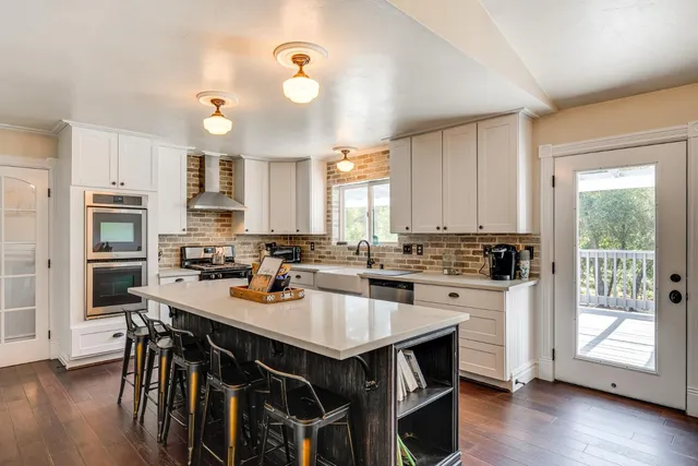 a kitchen with a stove a refrigerator and a stove top oven