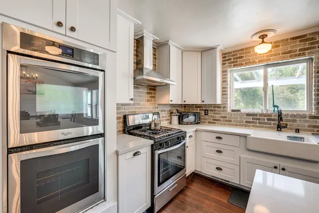 a kitchen with stainless steel appliances white cabinets and a stove
