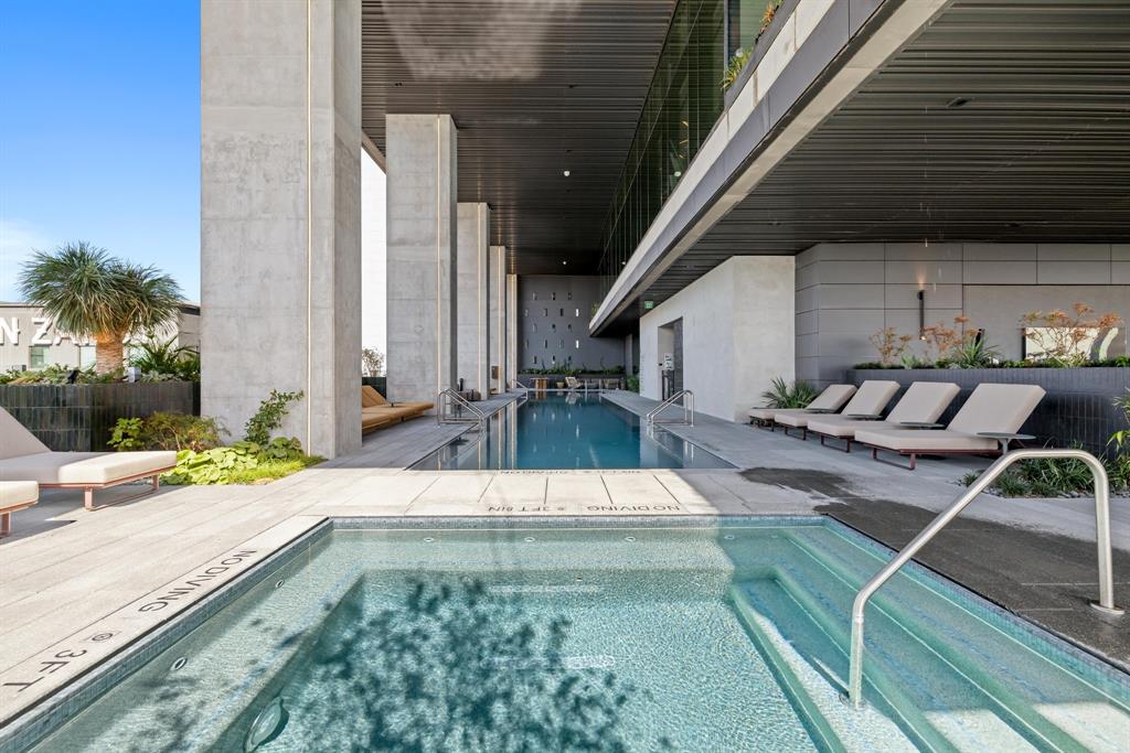 Community pool featuring a hot tub and a patio area