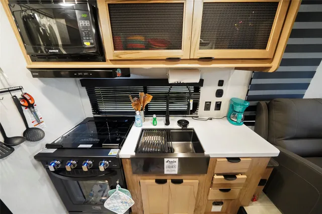 a kitchen with a large window and a ceiling fan