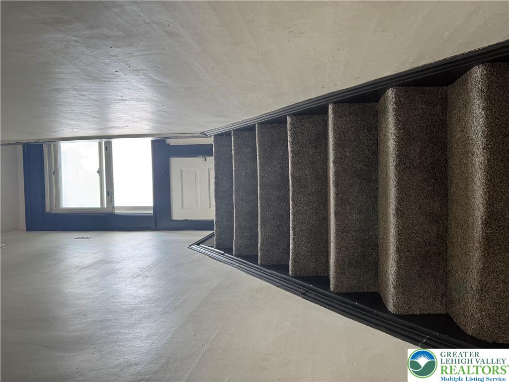 41 West Ridge Street Lansford, PA 18232 - Photo 27 of 40 Plush carpeted stairs ascend to a naturally illuminated landing with a window.