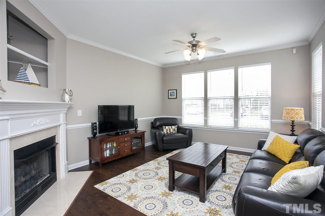7725 Winners Edge Street Raleigh, NC 27617 - Photo 2 of 25 a living room with furniture a fireplace and a flat screen tv