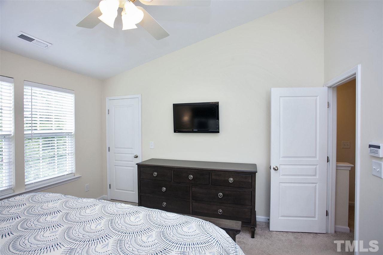 7725 Winners Edge Street Raleigh, NC 27617 - Photo 14 of 25 a bedroom with a bed and a flat screen tv
