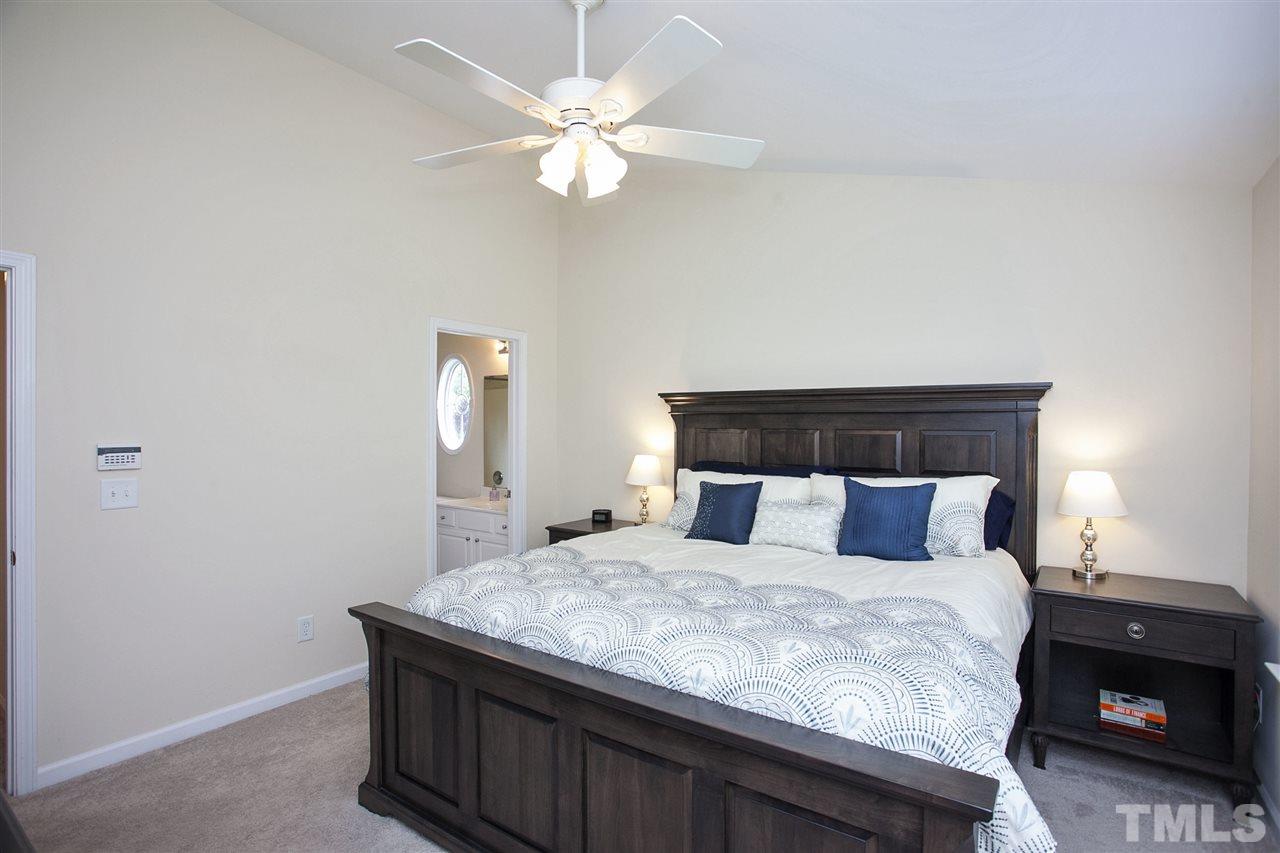 7725 Winners Edge Street Raleigh, NC 27617 - Photo 15 of 25 a bedroom with a bed and a chandelier