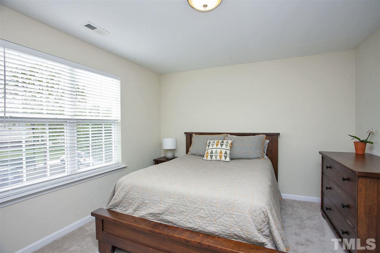7725 Winners Edge Street Raleigh, NC 27617 - Photo 17 of 25 a large bed sitting in a bedroom next to a window