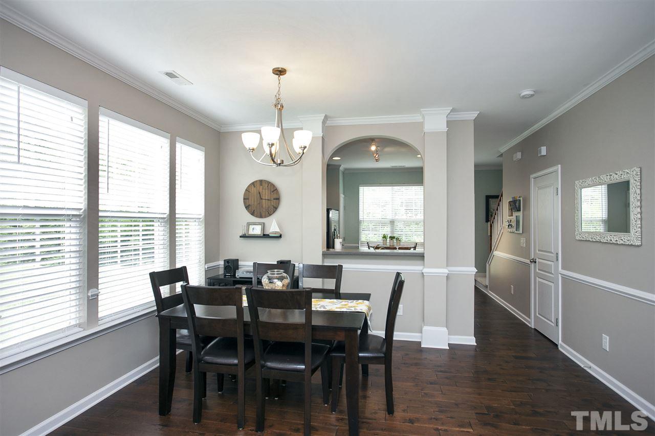 7725 Winners Edge Street Raleigh, NC 27617 - Photo 6 of 25 a view of a dining room with furniture a chandelier and wooden floor