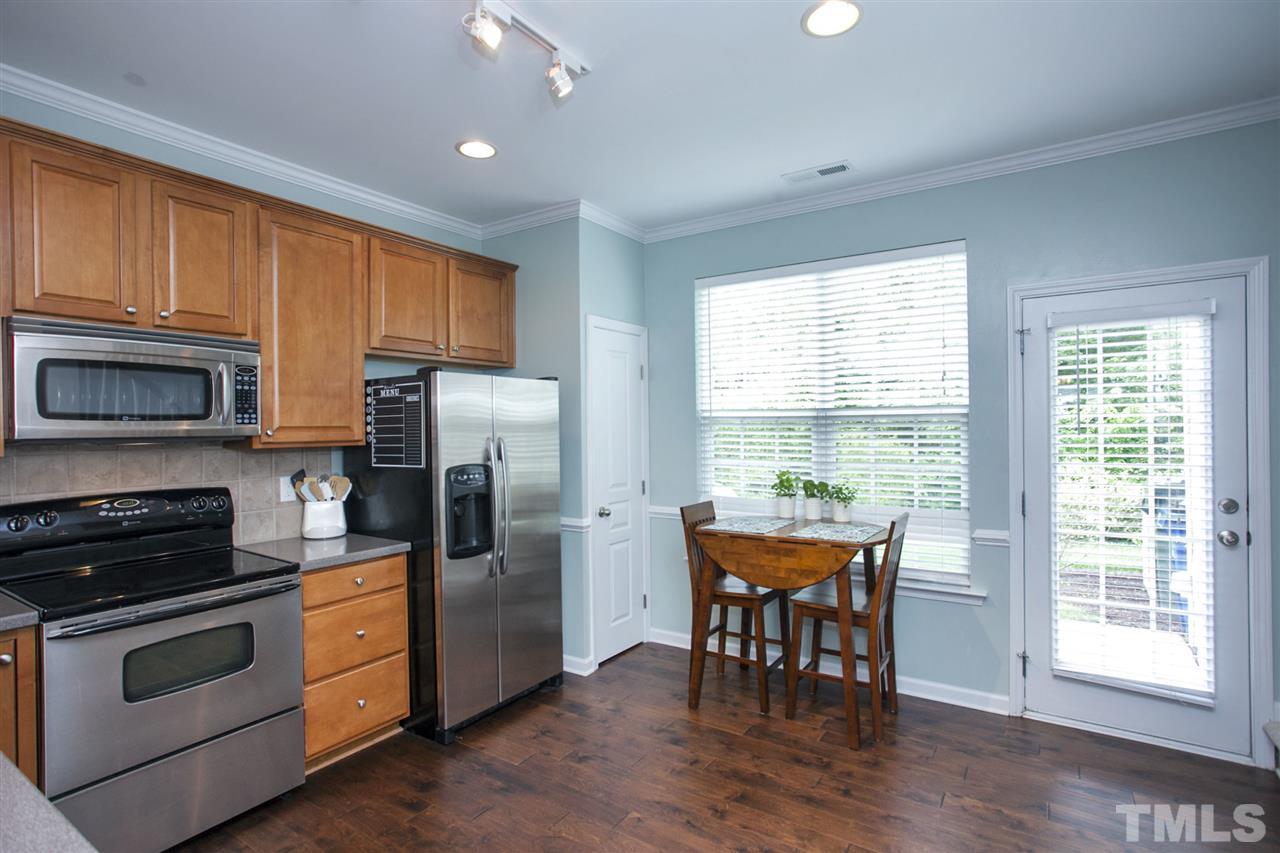 7725 Winners Edge Street Raleigh, NC 27617 - Photo 8 of 25 a kitchen with a table chairs microwave and refrigerator