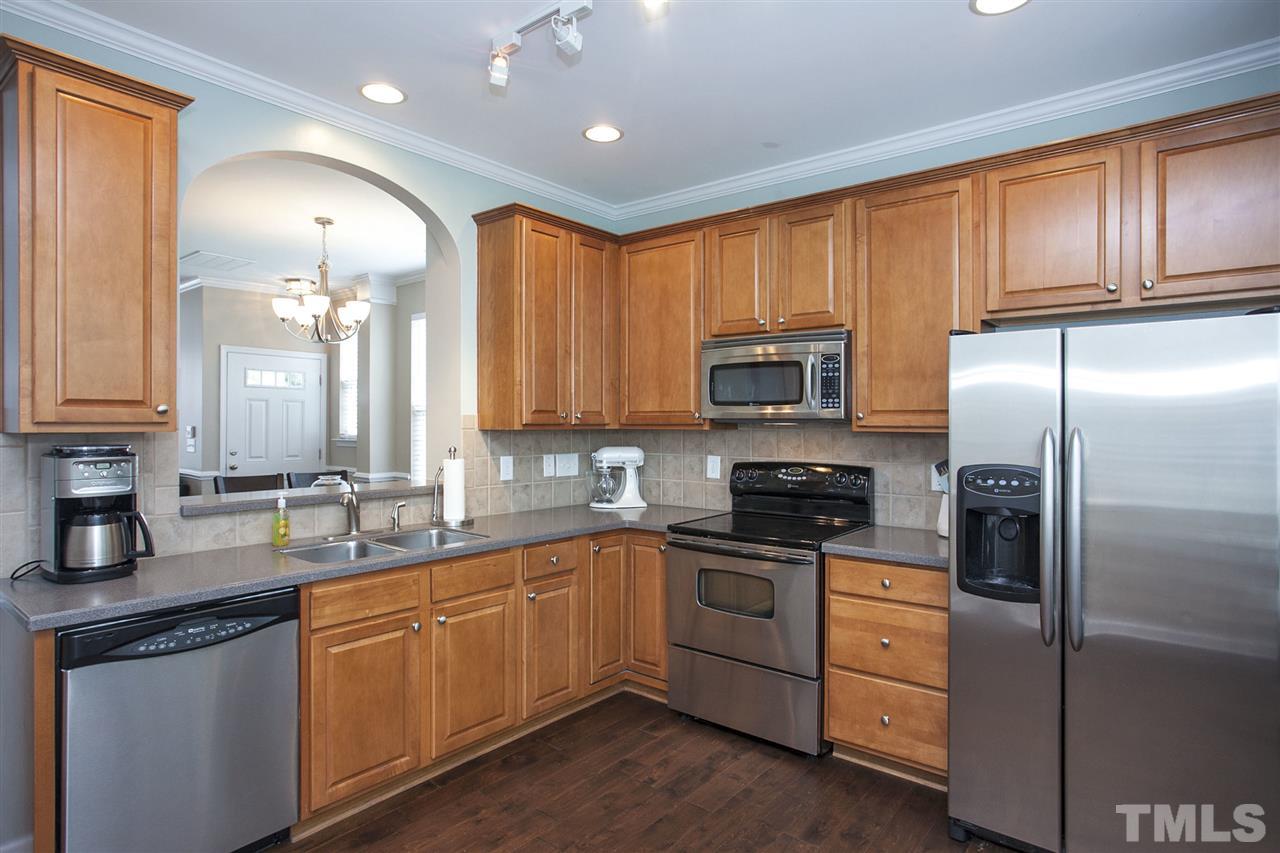 7725 Winners Edge Street Raleigh, NC 27617 - Photo 9 of 25 a kitchen with stainless steel appliances granite countertop a sink stove and refrigerator