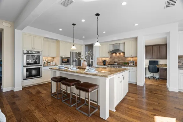 a view of a hallway with wooden floor and a bathroom