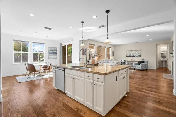 a kitchen with stainless steel appliances granite countertop a table and chairs in it