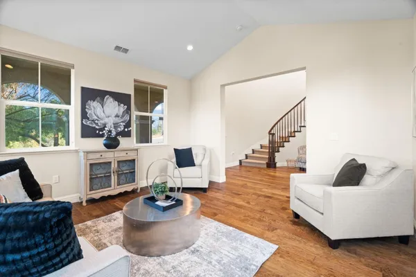 a view of a dining room with furniture a chandelier and wooden floor