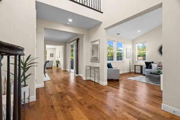 a view of a dining room with furniture a chandelier and wooden floor