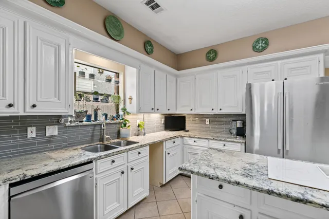 a kitchen with a sink window and cabinets