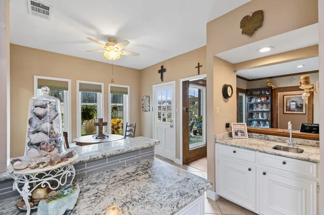a large spacious bathroom with a granite countertop sink a mirror and shower