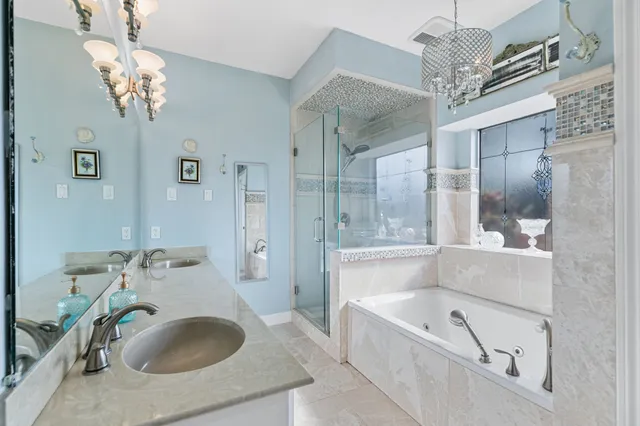 a bathroom with a tub sink a mirror and a shower