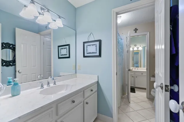 a bathroom with a double vanity sink mirror and toilet