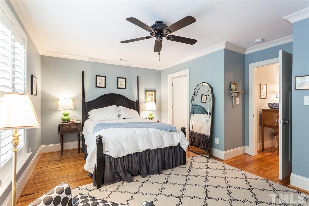 507 Adams Street Raleigh, NC 27605 - Photo 17 of 30 a bedroom with a bed and wooden floor