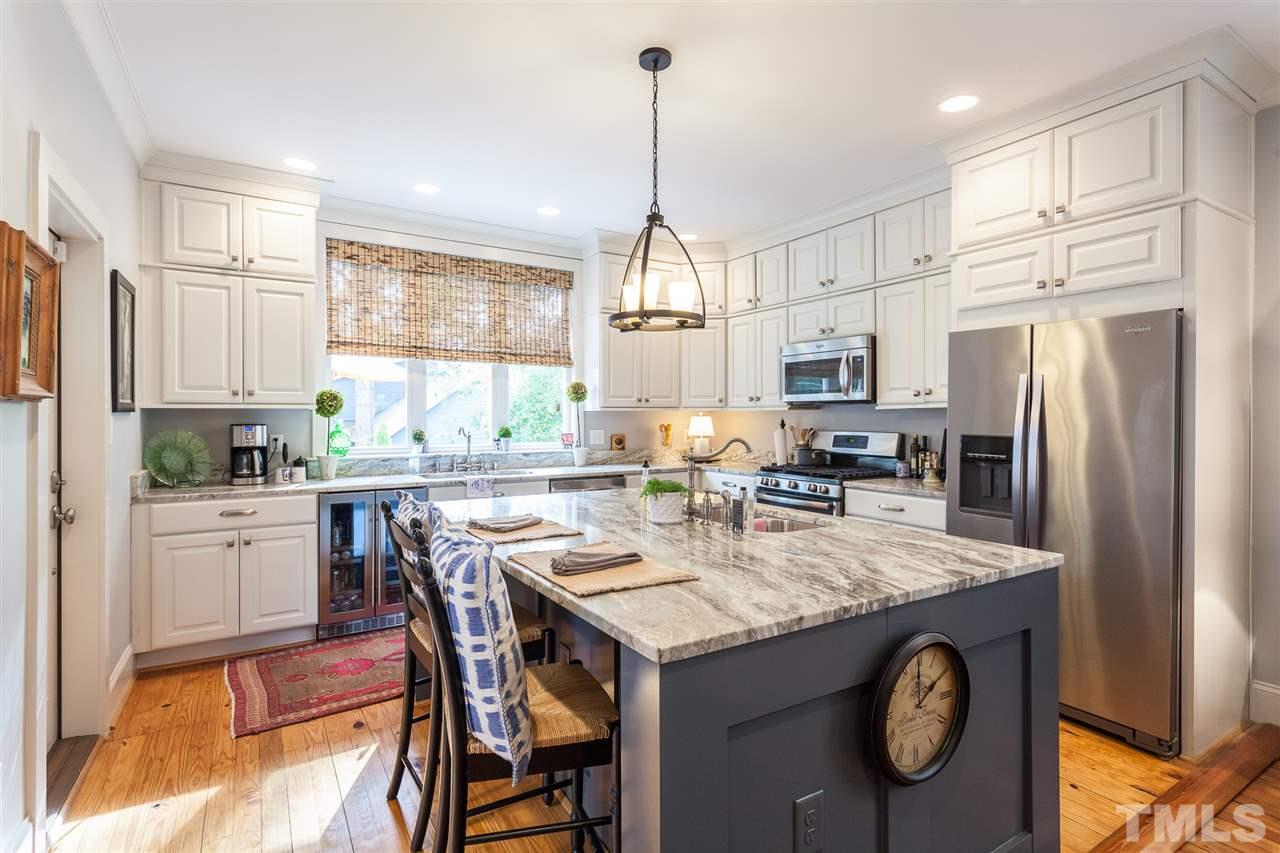 507 Adams Street Raleigh, NC 27605 - Photo 3 of 30 a kitchen with stainless steel appliances granite countertop a kitchen island a stove a table and chairs