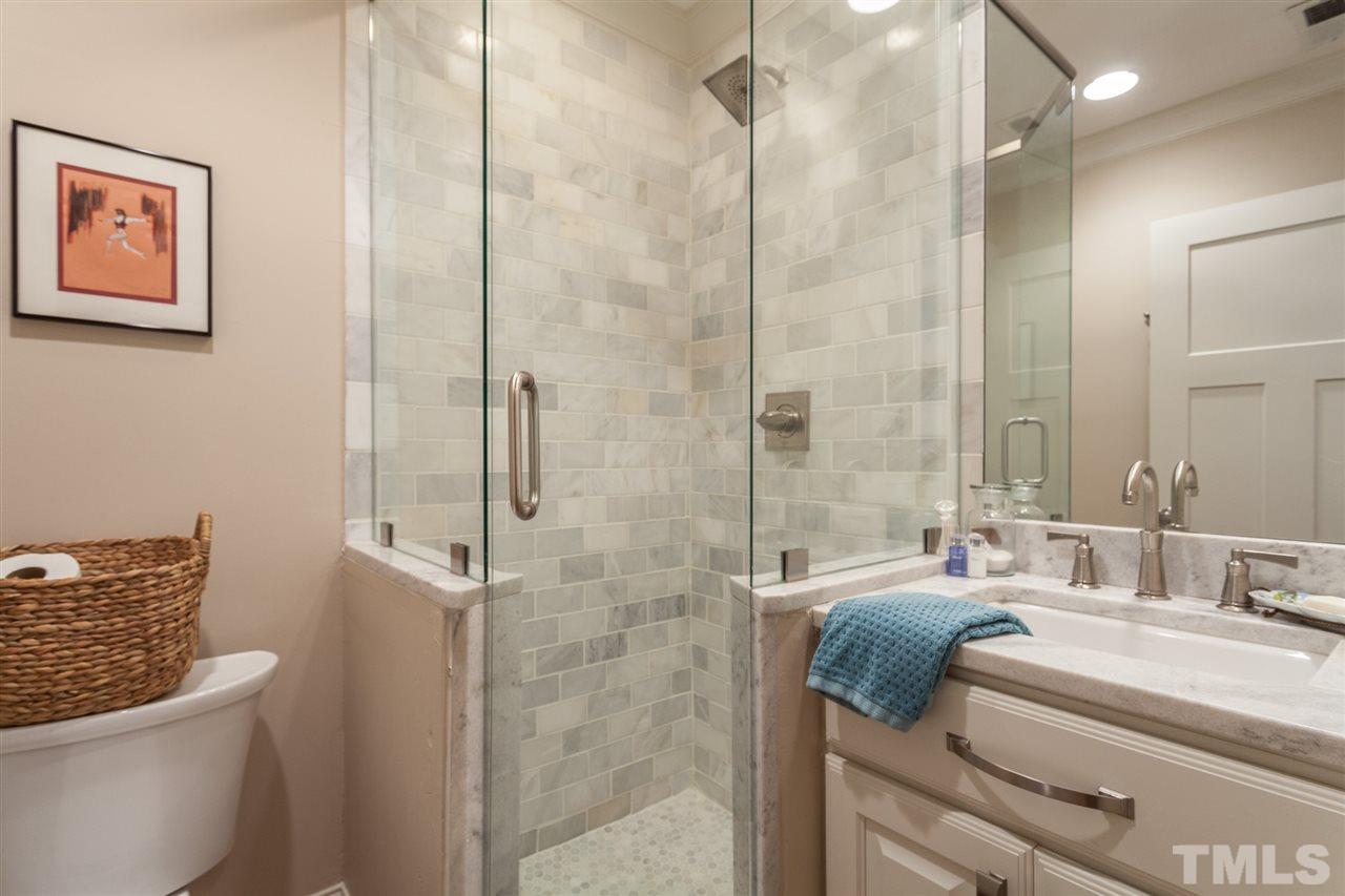 507 Adams Street Raleigh, NC 27605 - Photo 21 of 30 a bathroom with a granite countertop sink a toilet a mirror and shower